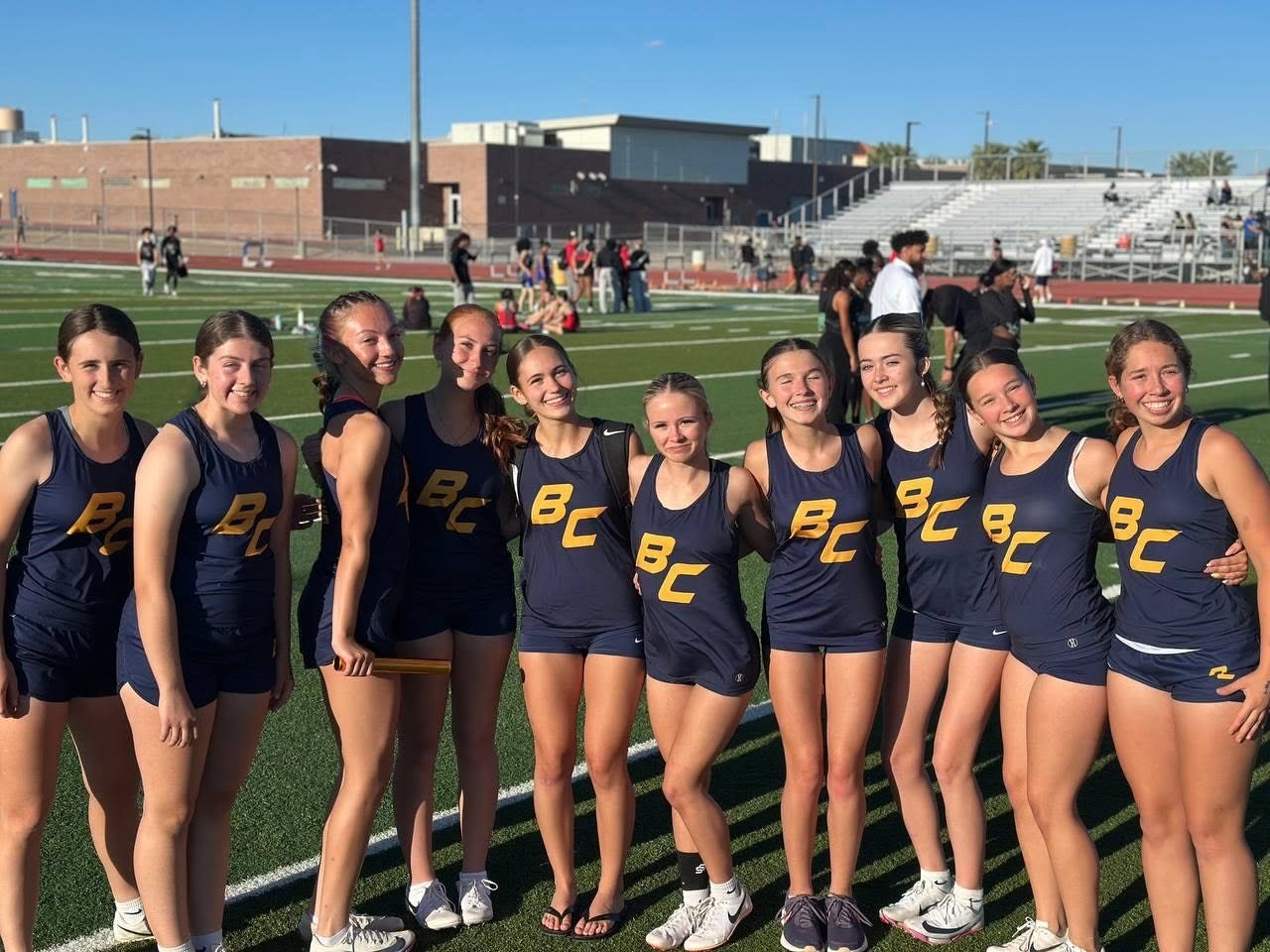 Full Lady Eagles roster posing together on the football field turf